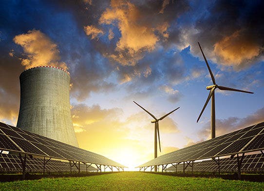 Solar energy panels before a nuclear power plant and wind turbines at sunset