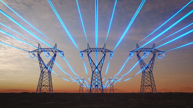 Steel transmission towers stretch across a desert plain at sunset while glowing blue strands symbolize data-intensive artificial intelligence increasing power consumption.